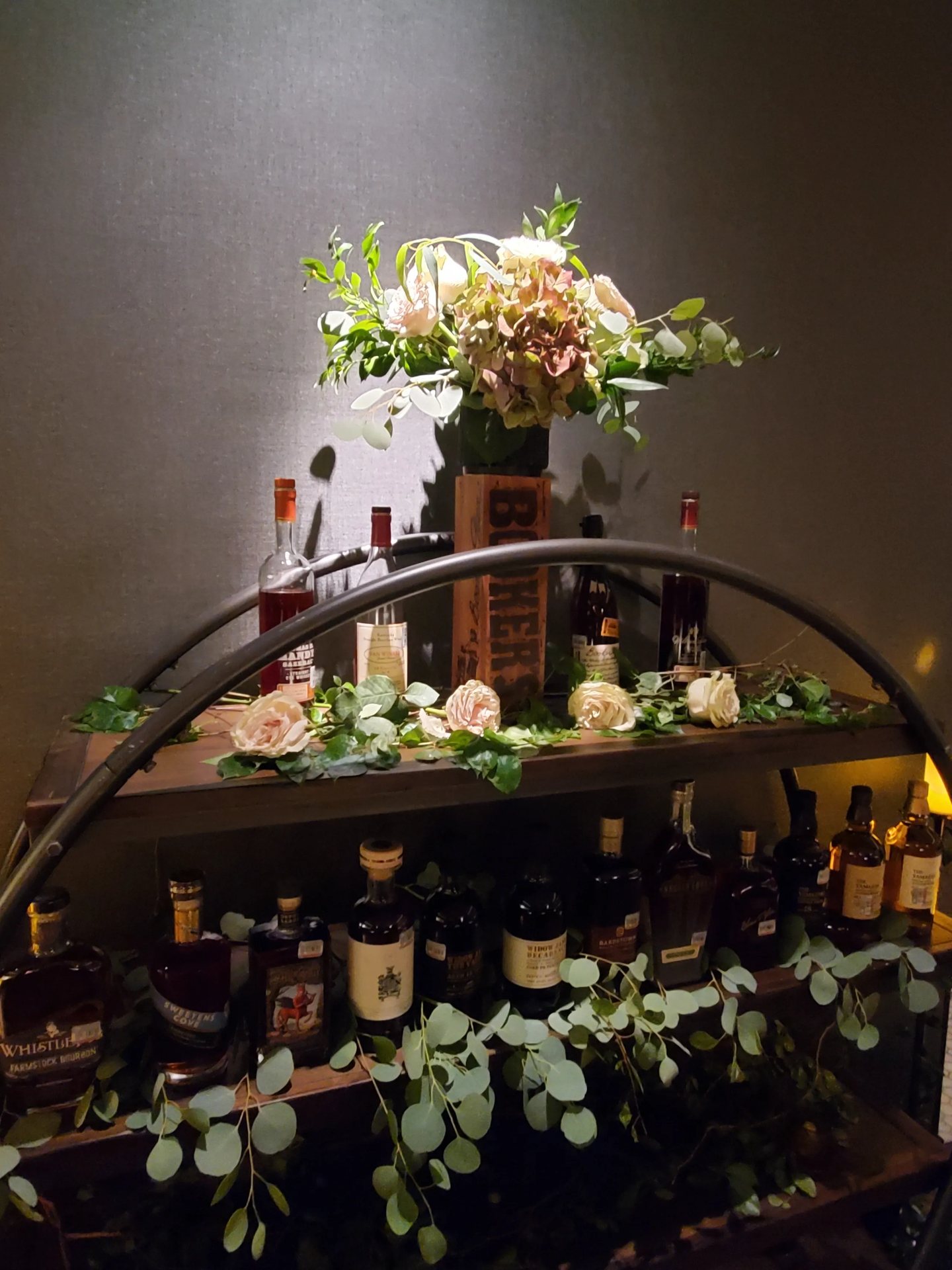 Custom greenery garland draped over a bar cart at Dean's Steakhouse