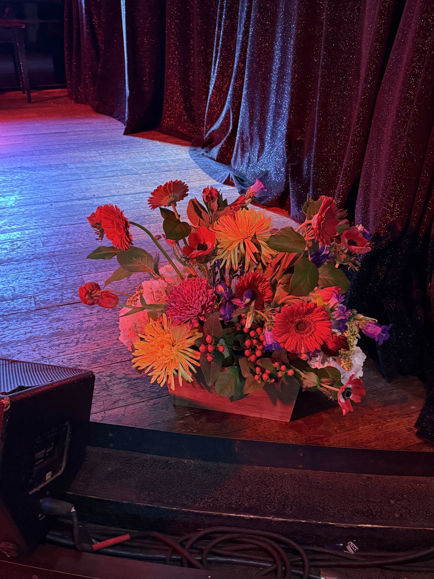 Bold gerbera and spider mum stage arrangement at a live corporate event in Austin